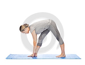 Woman making yoga intense stretch pose on mat