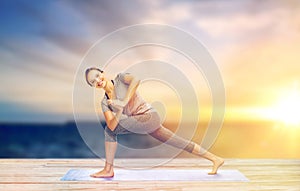 Woman making yoga low angle lunge pose on mat