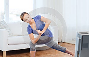 Woman making yoga low angle lunge pose on mat