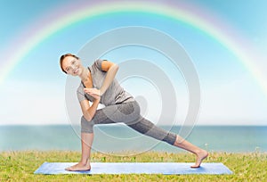 Woman making yoga low angle lunge pose on mat