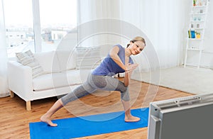 Woman making yoga low angle lunge pose on mat