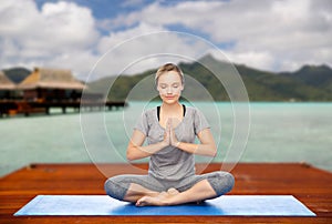 Woman making yoga in and meditating lotus pose