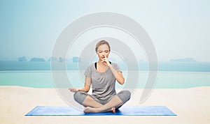 Woman making yoga meditation in lotus pose on mat