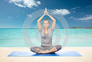 Woman making yoga meditation in lotus pose on mat