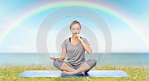 Woman making yoga meditation in lotus pose on mat