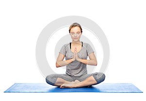Woman making yoga meditation in lotus pose on mat