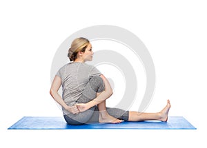 Woman making yoga in twist pose on mat