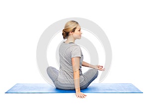 Woman making yoga in twist pose on mat