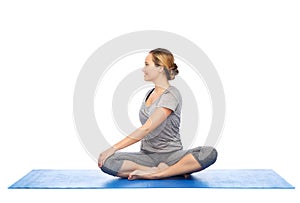 Woman making yoga in twist pose on mat