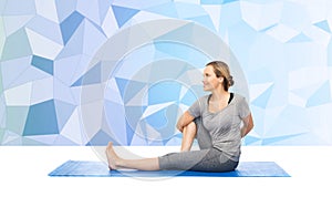 Woman making yoga in twist pose on mat