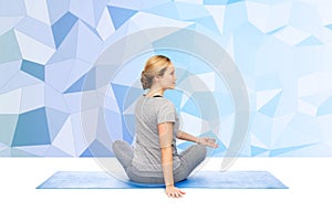 Woman making yoga in twist pose on mat