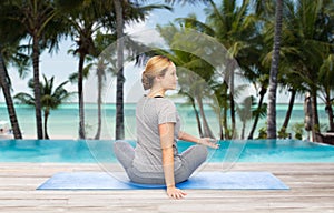 Woman making yoga in twist pose on mat