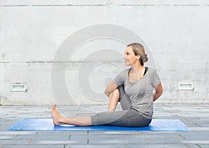 Woman making yoga in twist pose on mat