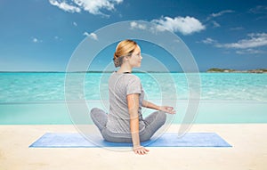 Woman making yoga in twist pose on mat