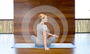 Woman making yoga in twist pose on mat