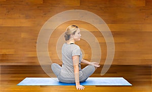 Woman making yoga in twist pose on mat