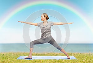 Woman making yoga warrior pose on mat