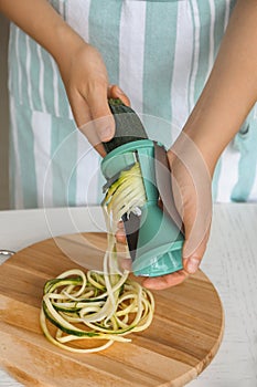 Woman making zucchini spaghetti, closeup