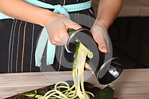 Woman making zucchini spaghetti, closeup