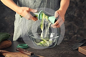 Woman making zucchini spaghetti, closeup