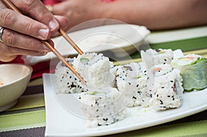 woman with makis and chopsticks at the chinese restau photo