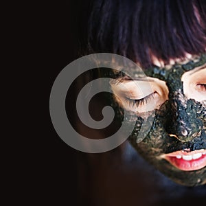 Woman makng black clay mask