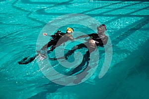 Woman and male divemaster, lesson in diving school