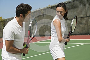 Woman and male tennis instructor practising racket control on tennis court