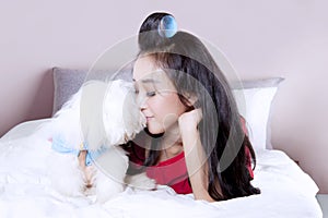 Woman with Maltese puppy on bed