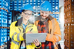 Woman and man as workers in logistics center using computer