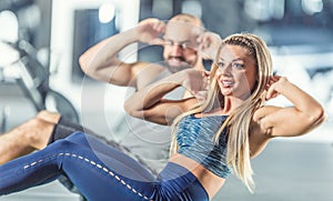 Woman and man athletic couple strengthen abdominal muscles in gym. Core strength training exercise