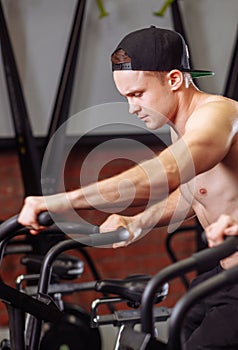 Woman and man biking in gym, exercising legs doing cardio workout cycling bikes