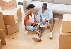 Woman, man and boxes in pregnancy as happy for moving, house and relocating on floor in living room. African, couple and photo