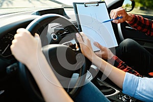 Woman and man with checklist, driving school