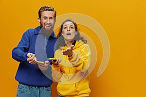 Woman man cheerful couple with phones in hand social networking and communication crooked smile fun and fight, in yellow