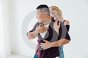 a woman and a man dancing to the music of a bachata in a white hall