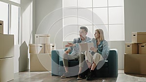 Woman and man discuss apartment interior sitting on sofa