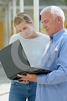 woman with man discussing over laptop outdoors