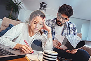 Woman and man doing paperwork together, paying taxes online photo
