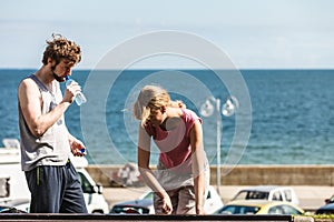 Woman and man drinking water outdoor.