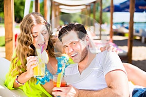 Woman and man with drinks in beach bar