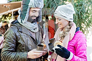 Woman and man eating and drinking on Christmas market