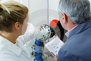 Woman and man engineers testing circuit board photo