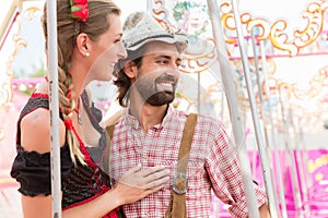 Woman and man enjoying a swing on the Oktoberfest