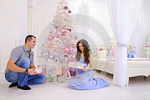 Woman and man hand Christmas presents its half in spacious bedro