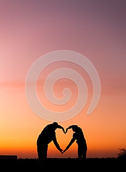 Woman and man hand silhouette over sky at sunset background