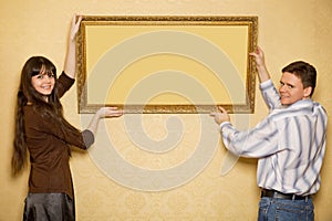 Woman and man hang up on wall picture