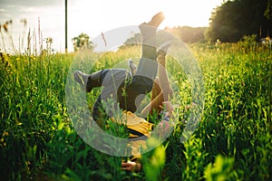 woman and man having fun outdoors. Loving hipster couple walking in the field, kissing and holding hands, hugging, lying