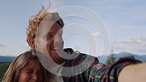 Woman and man having video chat at hike in mountains. Guy gesturing with hand