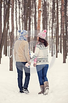 Woman and man are having walk in winter snowy countryside.